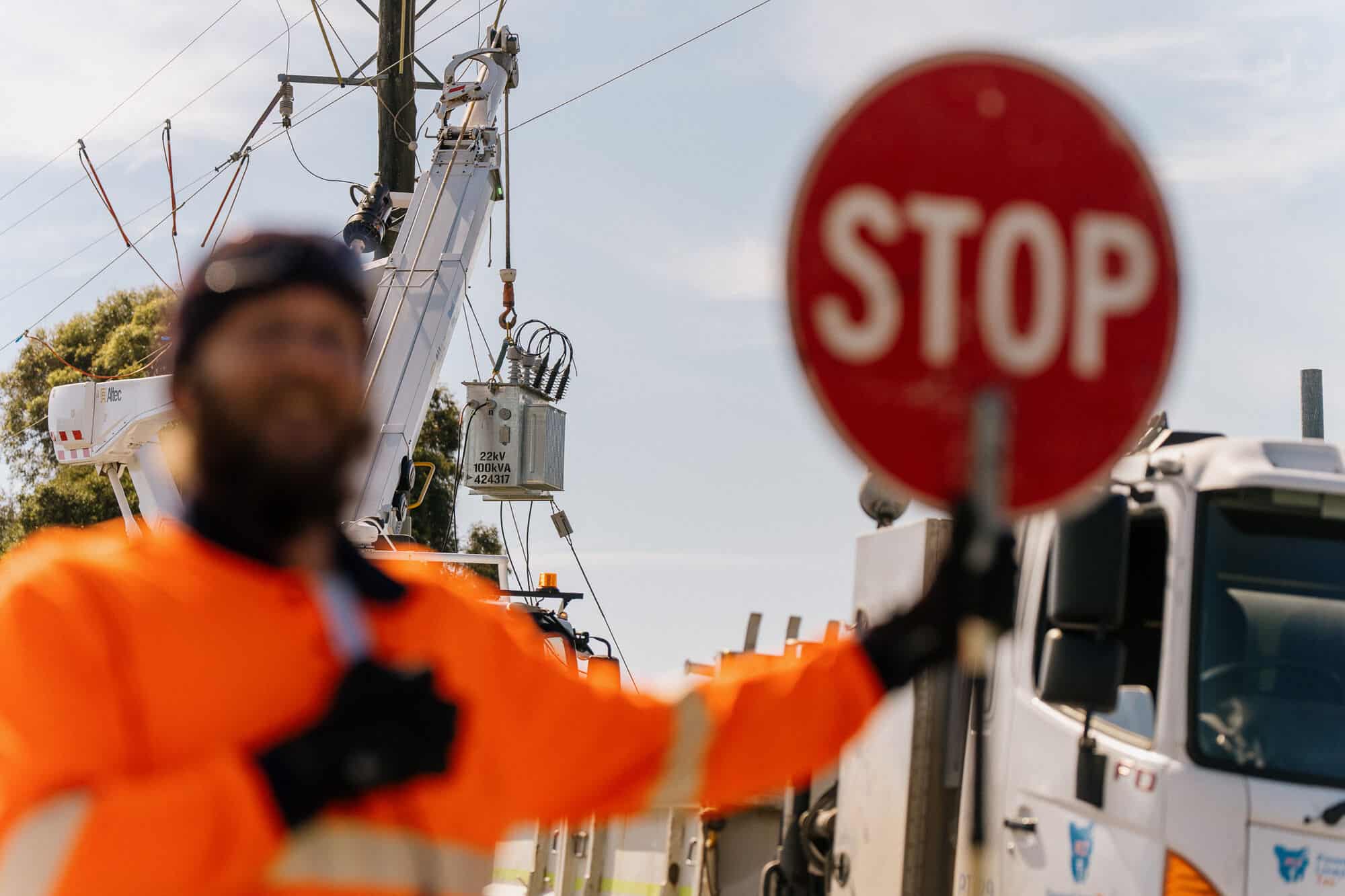 Traffic controller in orange hi-vis with STOP sign
