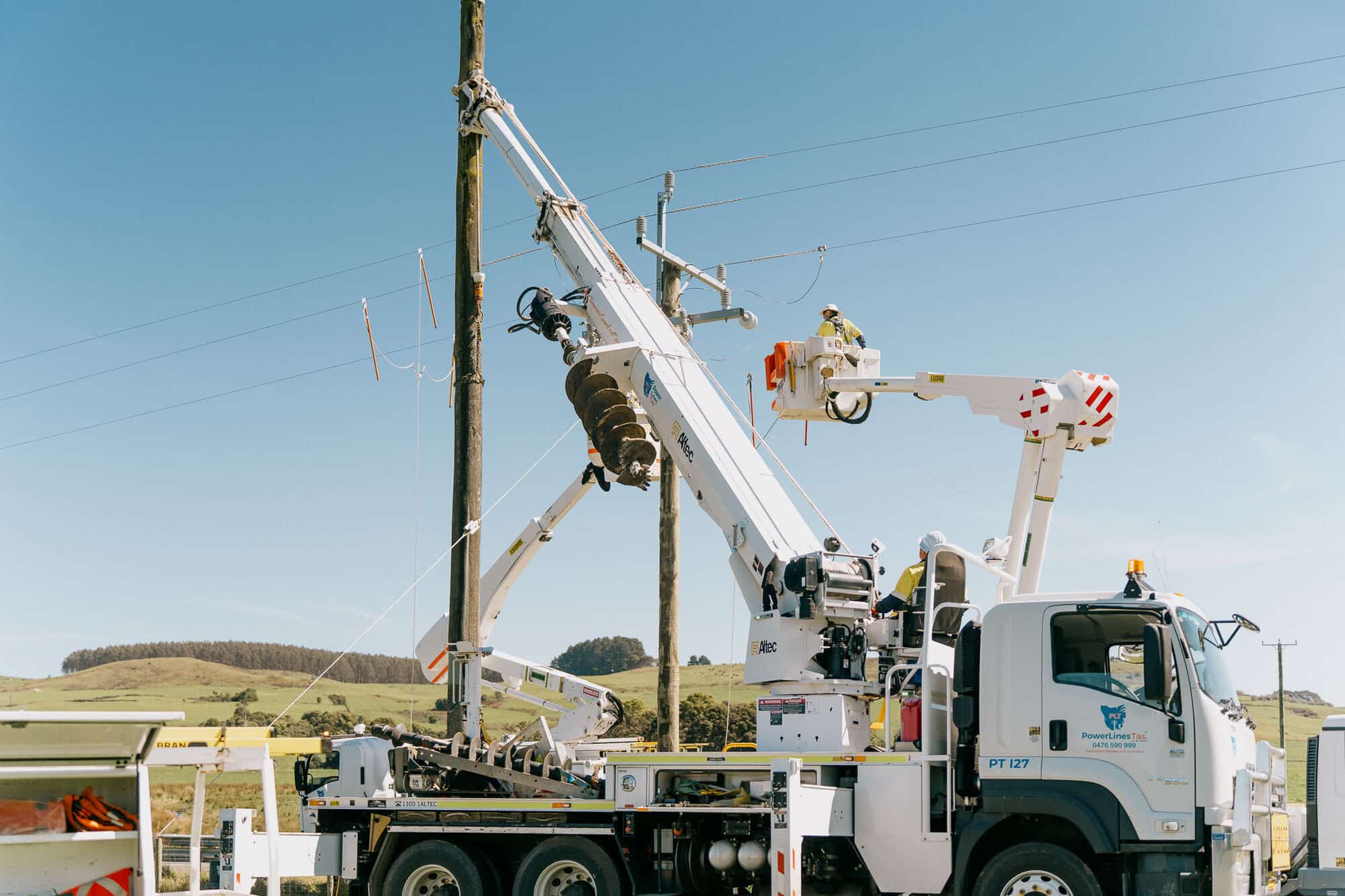PLT crane truck and bucket working on a power pole in the Tasmanian countryside